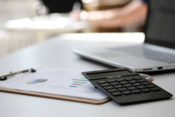 istock Black calculator and financial statistics on clipboard pad 693451008