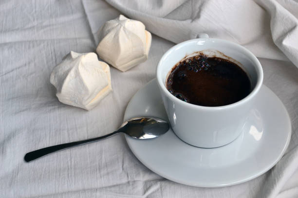 Cup with coffee and marshmallow in bed stock photo