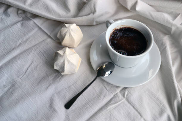 istock Cup with coffee and marshmallow in bed 693460124