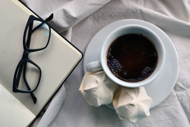 istock Cup of coffee, notepad and glasses in bed 693460260