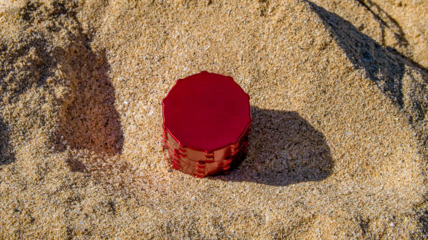 istock Red cannabis grinder on sand 693464386