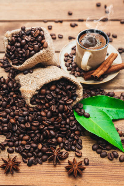 istock Coffee cup and beans on old wooden table 693465820