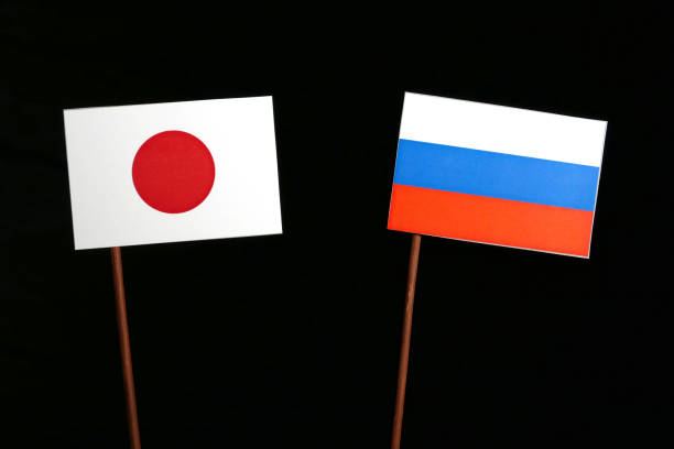 istock Japanese flag with Russian flag isolated on black background 693466892