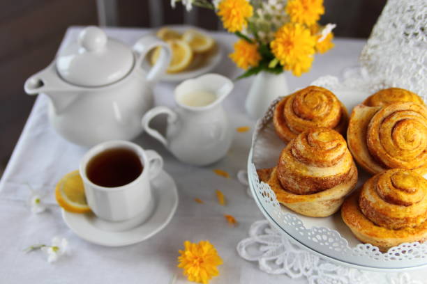 cinnamon buns breakfast with fresh buns with cinnamon, tea and a bouquet of flowers tea party horizontal nobody indoors stock pictures, royalty-free photos & images
