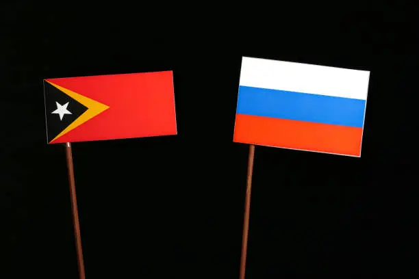 Photo of East Timorese flag with Russian flag isolated on black background