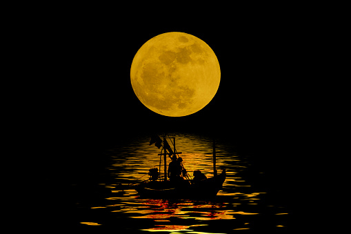 Abstract of silhouette of fishing boat on the sea with full moon on background