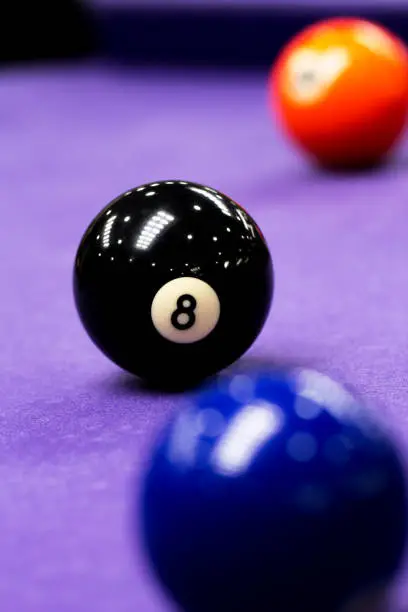 Close-up of a black 8 ball on pool table