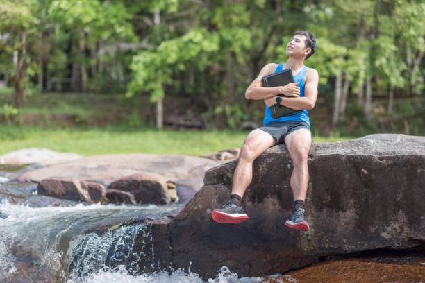 istock Hiker backpack with laptop and phone at  waterfall  the forest. 693513886