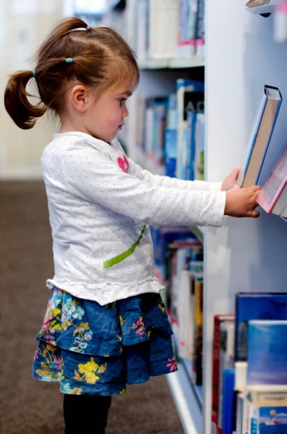 istock Preschool girl in library 693525650