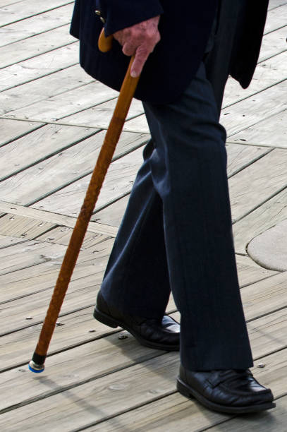 istock Low angle of elderly man walking with wood cane stick 693528002