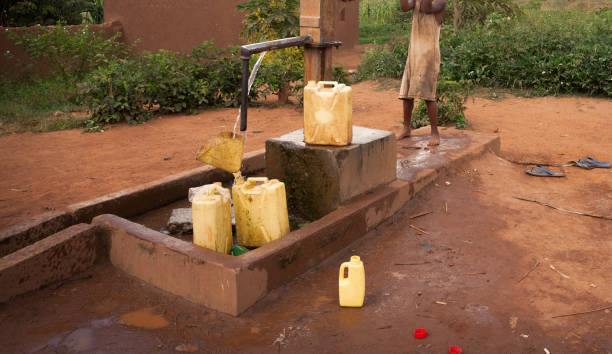 istock Using water pump at a water well in East Africa 693529196