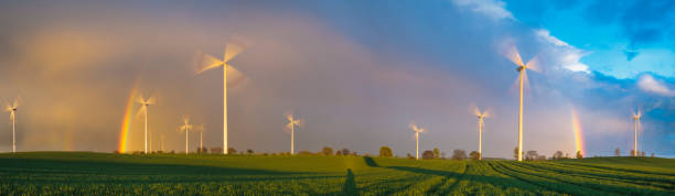 istock Rainbow over the field and windmills 693541446