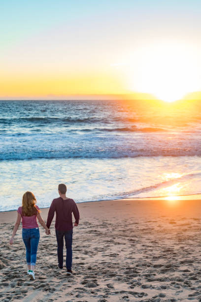 istock Happy Young Couple Walking at Sunset on Venice Beach 693547298