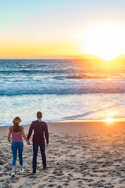 istock Happy Young Couple Walking at Sunset on Venice Beach 693547322