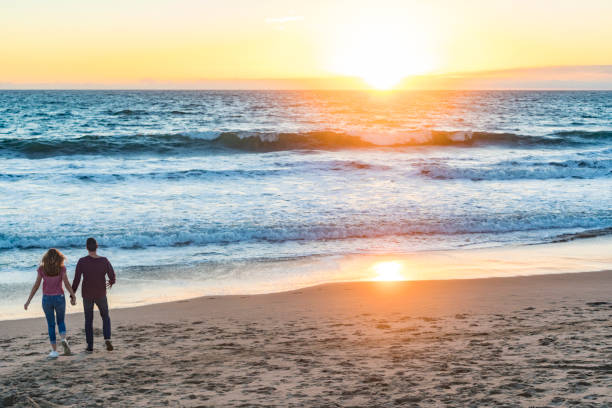 istock Happy Young Couple Walking at Sunset on Venice Beach 693547344