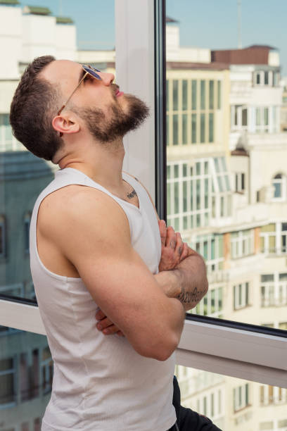 istock A guy with a beard looks out the window 693548108