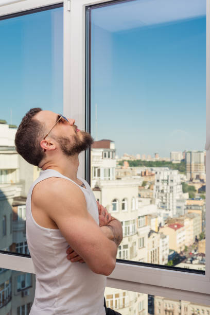 istock A guy with a beard looks out the window 693548172