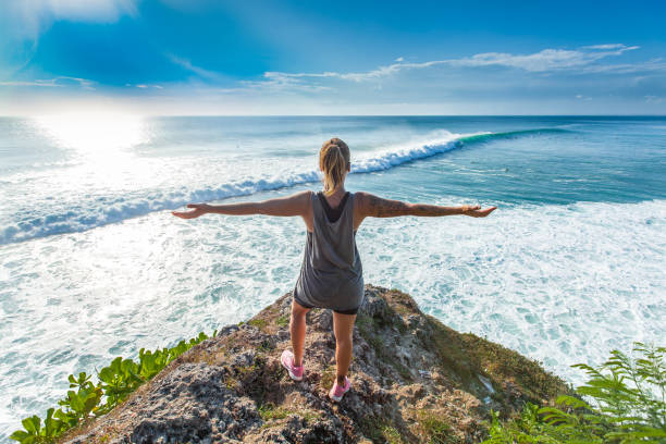 istock Surfer girl welcoming waves with open arms 693553324