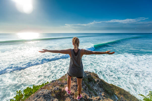 istock Surfer girl welcoming waves with open arms 693553558