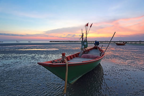istock Sunset at anchor fishing boat at low tide 693553854