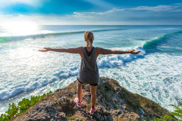 istock Surfer girl welcoming waves with open arms 693554892