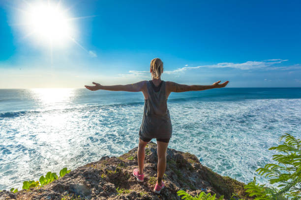 istock Surfer girl welcoming waves with open arms 693554940