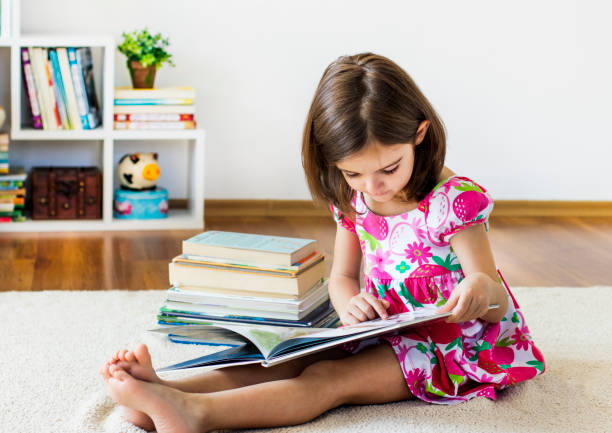 istock Cute girl reading a book 693560880