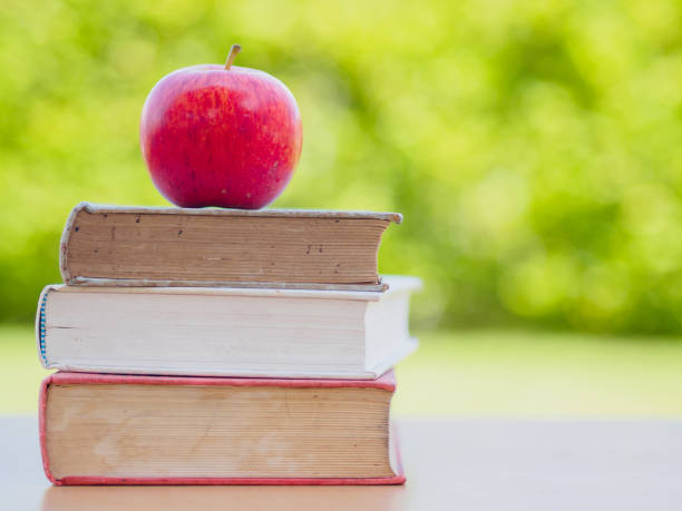 istock World Book Day concept. Red apple and pen put on stack of old books 693563204