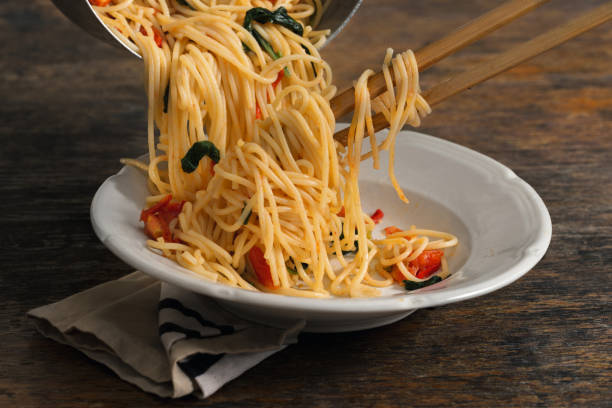 istock Italian pasta in a white plate on a rustic wooden table 693564090