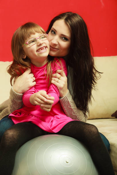 istock Mother sitting on exercise ball with daughter 693567398