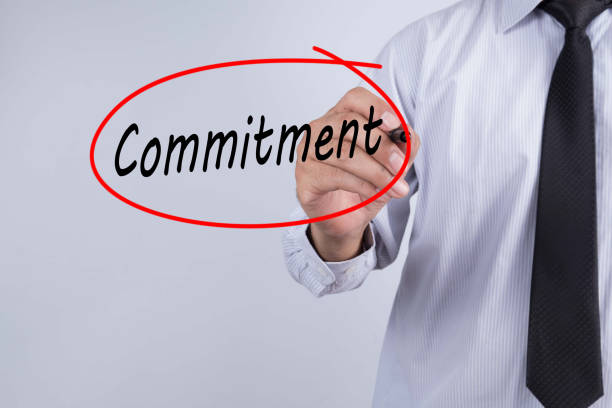 istock Businessman Hand Writing commitment with a marker over transparent board, Business concept. 693570118