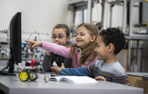 istock Group of happy children using desktop PC in a laboratory. 693573570