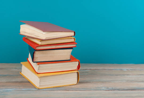 istock Book stacking. Open hardback books on wooden table and beige background. Back to school. Copy space for ad text 693576304