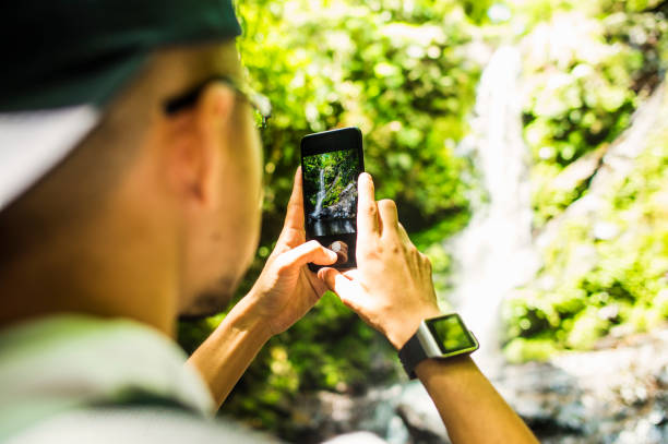 istock Mid adult man using a smart phone in the riverside 693583412