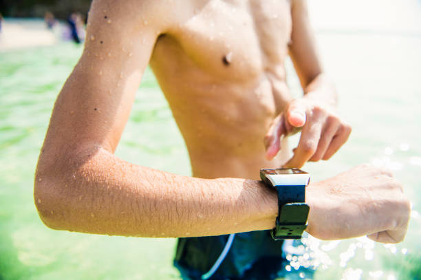 istock Mid adult man using a smart watch at the beach. 693584202