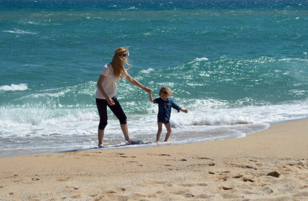 istock Mother and son having fun on the beach 693586412
