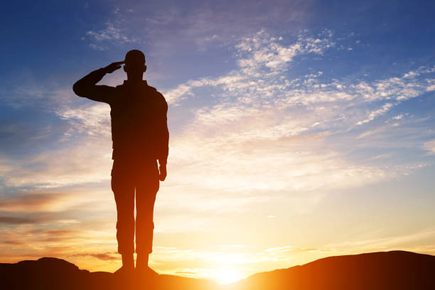saluto soldato. silhouette sul cielo al tramonto. esercito, militare. - saluting armed forces military army foto e immagini stock