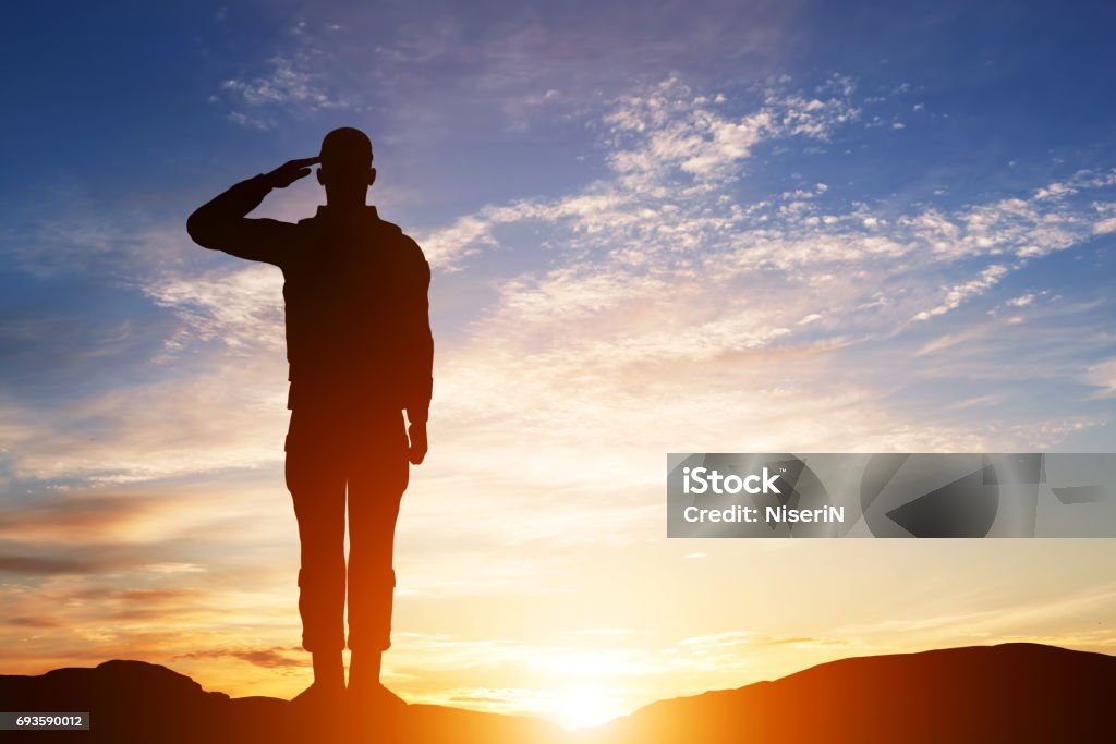 Soldier salute. Silhouette on sunset sky. Army, military. Soldier salute. Silhouette on sunset sky. War, army, military, guard concept. Saluting Stock Photo