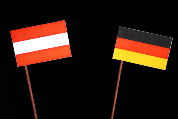 istock Austrian flag with German flag isolated on black background 693600374