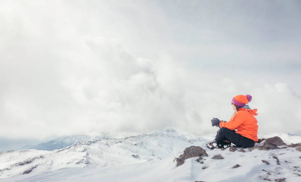 istock Alpine climber is drinking coffee while watching the beautiful landscape  in the peak of mountain in winter 693600494