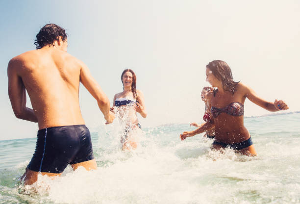 istock Friends splashing each other with water 693610682