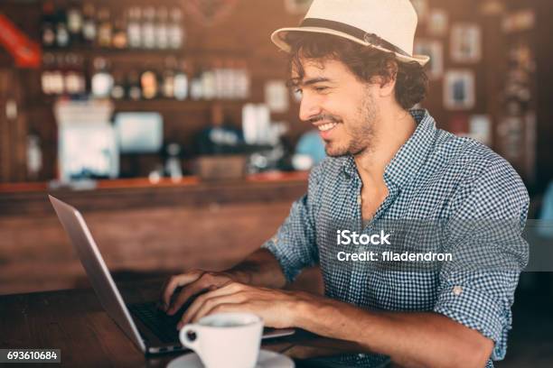 Attraktiver Mann Mit Einem Laptop Im Café Stockfoto und mehr Bilder von Fedora - Fedora, Hut, Arbeiten