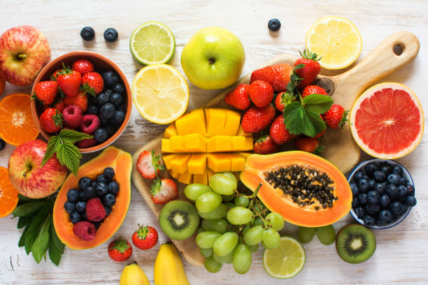 vista superior de frutas de arco iris en blanco - fruit salad freshness strawberry fotografías e imágenes de stock
