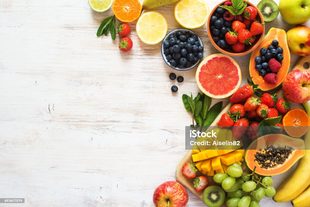 Rainbow fruits top view on white Above view of colorful fruits, strawberries, blueberries, mango, orange, grapefruit, banana, apple, grapes, kiwis on the white background, copy space for text, selective focus Fruit Stock Photo