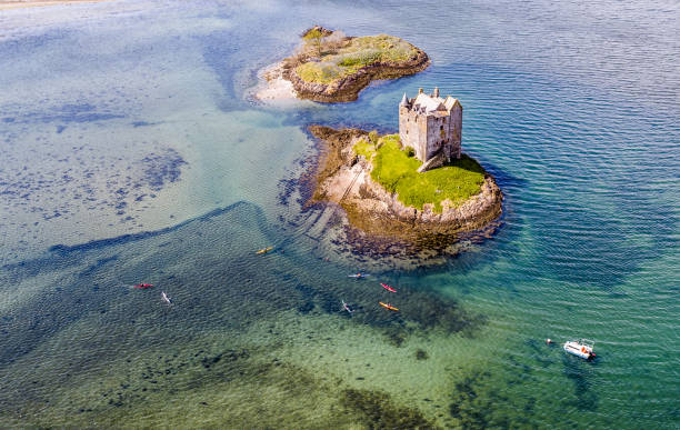 aerial canoes gathering around the historic castle stalker in argyll - loch rowboat lake landscape imagens e fotografias de stock