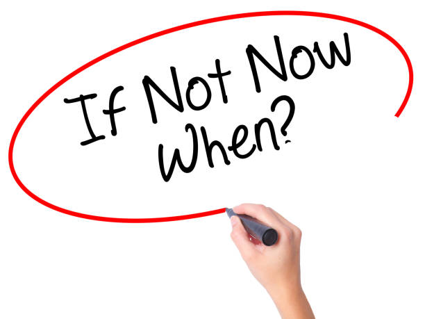 istock Women Hand writing If Not Now When? with black marker on visual screen 693623890