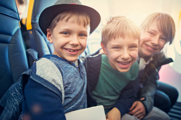 istock Happy kids sitting in plane 693624248