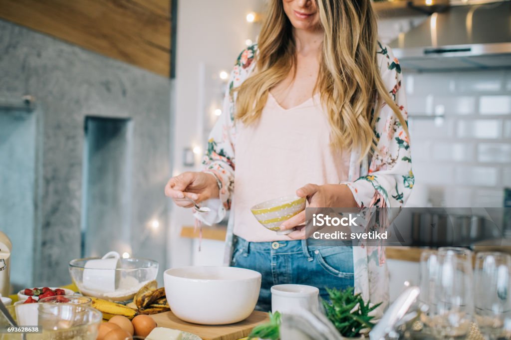 Preparing her favourite cake Lovely woman baking biscuits in her kitchen at home Cooking Stock Photo