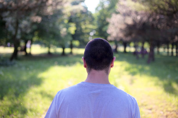 istock Lonely guy walking in the park 693631698