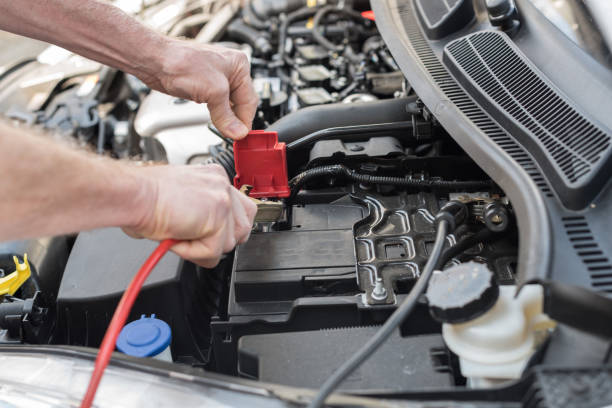 istock Hands of car mechanic using car battery jumper cable 693634316